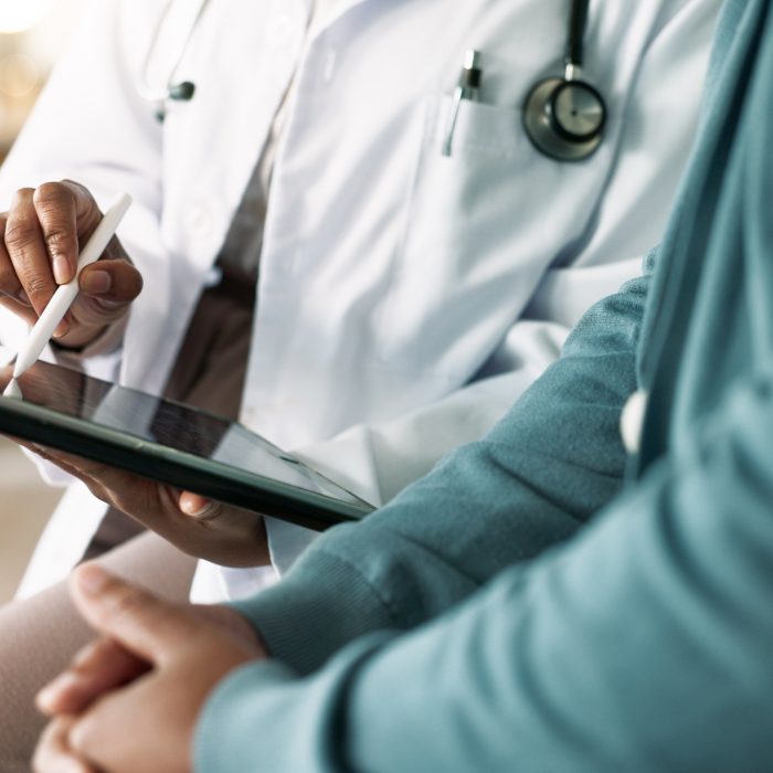 Doctor, hands and tablet with patient for consultation, medical advice or procedure at clinic. Closeup, healthcare employee and client with technology for health appointment or checklist at hospital