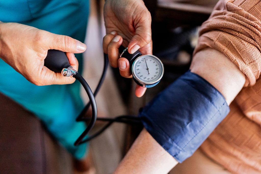 Caregiver measuring patient's blood pressure